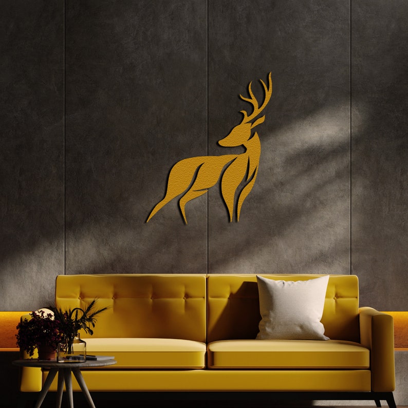 May include: A gold-colored deer silhouette wall decor mounted on a dark gray wall above a yellow sofa with a white pillow.