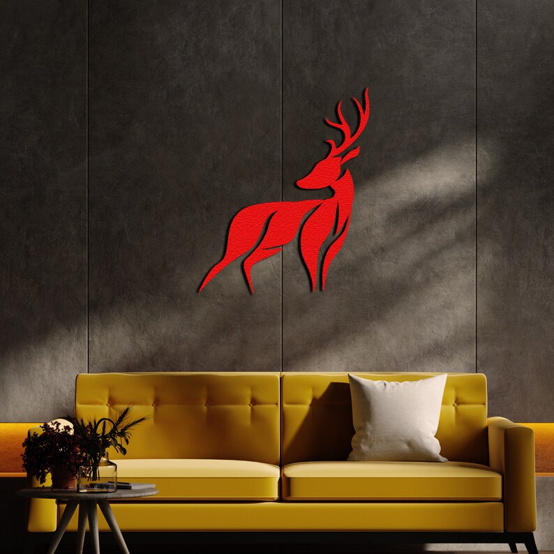 May include: A red deer silhouette wall decor in a modern living room setting. The deer is mounted on a dark gray wall above a yellow sofa with a white pillow.