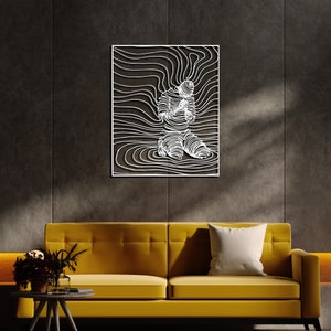 Op de afbeelding: Witte metalen wandkunst met een gestileerde menselijke figuur met vloeiende lijnen, die lijken op een golfpatroon. De figuur knielt met gevouwen handen voor de borst.