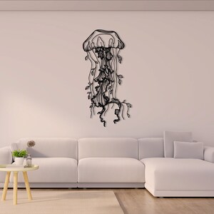 May include: A black metal wall sculpture of a jellyfish with intricate details. The jellyfish is depicted with flowing tentacles and a bell-shaped head.