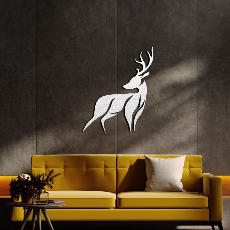 May include: White metal deer silhouette wall decor mounted on a dark gray wall above a yellow sofa with a white pillow.