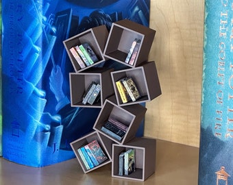 May include: A brown wooden bookshelf with a unique design, featuring multiple square compartments that are stacked and angled to create a modern and geometric look. The bookshelf is filled with small books, creating a visually appealing display.