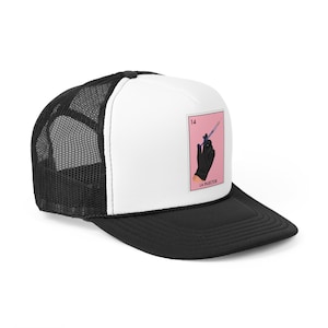 Könnte beinhalten: Eine schwarz-weiße Trucker-Kappe mit einem weißen Frontpanel, das eine rosa-weiße Illustration einer Hand mit einem schwarzen Handschuh zeigt, die eine Spritze hält. Die Illustration ist im Stil einer traditionellen mexikanischen Spielkarte mit der Nummer 14 und dem Text "LA INYECTOR" unter dem Bild.