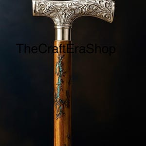 May include: A decorative walking stick with a silver-coloured handle featuring an ornate floral design. The wooden shaft is brown with turquoise accents. TheCraftEraShop is printed on the image.