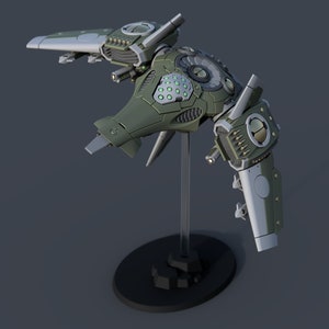 Può includere: Un modello di nave spaziale verde e grigia con un design dettagliato. Il modello è su un supporto nero con una base rotonda.