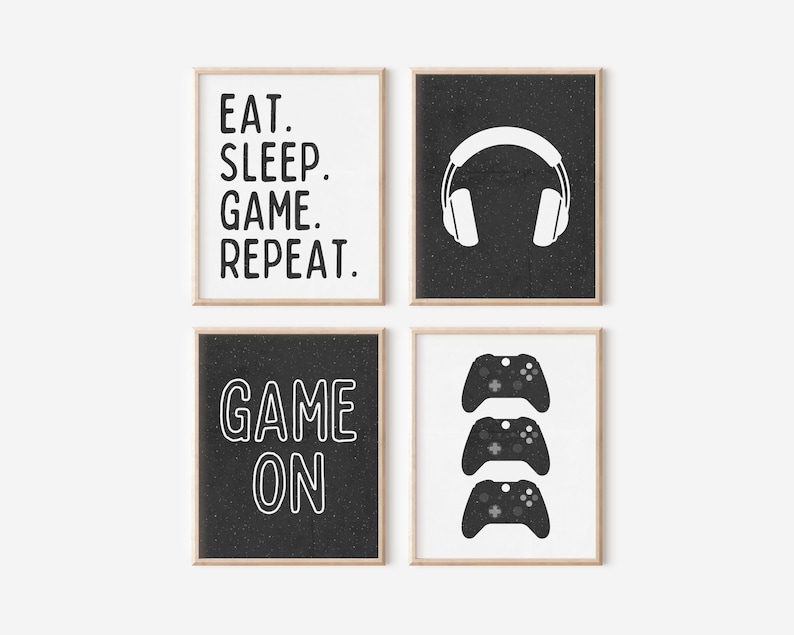 Pu&ograve; includere: Quattro stampe incorniciate in bianco e nero con testo e grafica a tema gamer. Le stampe presentano il testo "Eat. Sleep. Game. Repeat." e "Game On" insieme a immagini di cuffie e controller per videogiochi.