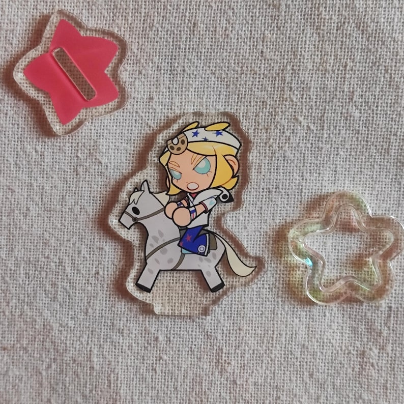 May include: Clear acrylic charms. One features a cartoon character on a white horse, another a pink star with a magnet, and a third is a clear star shape. The character has blonde hair and wears a white and blue outfit.