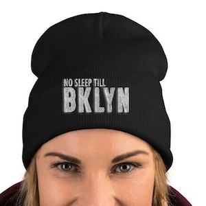 May include: Black beanie with a white embroidered design that says "NO SLEEP TILL BKLYN".