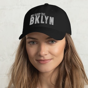 May include: A black baseball cap with the text "NO SLEEP TILL BKLYN" in white lettering.