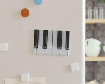 May include: A close-up of a black and white piano keyboard. The keys are arranged in a row, with the black keys alternating between groups of two and three.