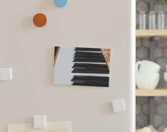 May include: A close-up of a black and white piano keyboard. The keys are slightly blurred, creating a sense of motion. The image is cropped to show only the keys, with no other details visible.