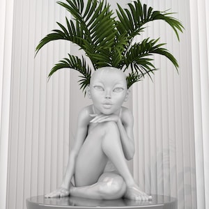 Può includere: Una scultura in ceramica bianca di una persona seduta con le gambe incrociate. La scultura ha una pianta che cresce dalla cima della testa.