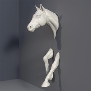 Peut inclure: Tête de cheval et deux jambes en céramique blanche montées sur un mur gris. La tête de cheval est tournée vers la gauche et les jambes sont positionnées comme si le cheval courait.