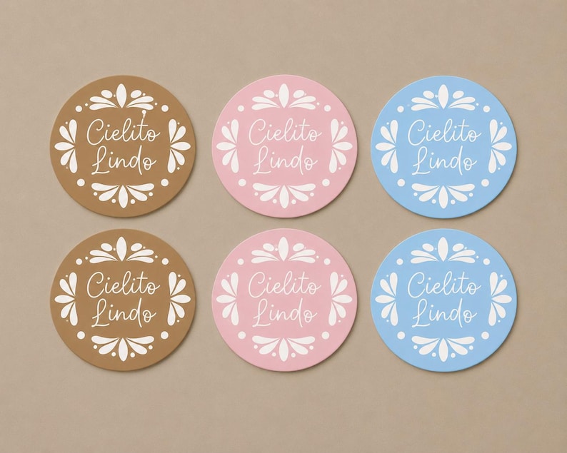 May include: Six circular stickers arranged in two rows of three. The stickers come in brown, pink, and light blue, each featuring a white decorative floral border and the text Cielito Lindo written in a white cursive script in the center.