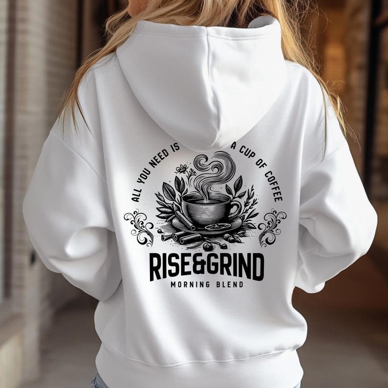 May include: White hoodie with a black and white graphic on the back. The graphic features a coffee cup with steam, surrounded by leaves and cinnamon sticks, and the text "ALL YOU NEED IS A CUP OF COFFEE" and "RISE&GRIND MORNING BLEND".