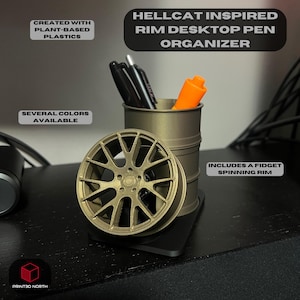 May include: A gold-colored desktop pen organizer shaped like a car rim. The organizer has a spinning rim and is made from plant-based plastics. The text "HELLCAT INSPIRED RIM DESKTOP PEN ORGANIZER" is at the top of the image. The text "INCLUDES A FIDGET SPINNING RIM" is at the bottom of the image.