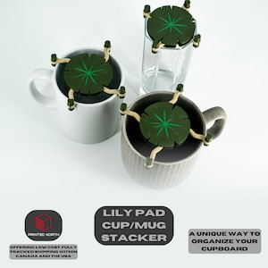 Puede incluir: Tres apiladores de tazas con forma de nenúfar verde y marrón. Los apiladores están diseñados para sostener tazas y jarras en un armario. El texto "Lily Pad Cup/Mug Stacker" está impreso en un rectángulo negro debajo de la imagen.