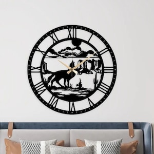 Puede incluir: Reloj de pared de metal negro con números romanos y una silueta de un coyote en un paisaje desértico.