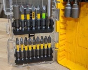 May include: A clear plastic case filled with a variety of yellow and black drill bits. The bits are organized in two rows and are labeled with different sizes and types.