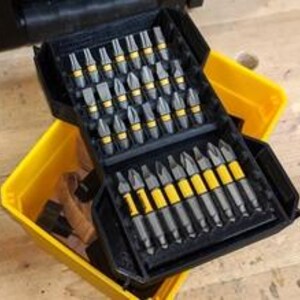 May include: A black and yellow plastic case filled with a variety of screwdriver bits. The case is open and the bits are arranged in rows.