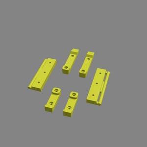 May include: A set of eight yellow plastic pieces for building or crafting. The pieces are various shapes and sizes, including rectangles, squares, and L-shapes.