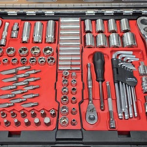 May include: A comprehensive tool kit in a black case with a red interior. The set contains sockets, ratchets, wrenches, and screwdriver bits. The tools are made of shiny metal and are neatly arranged for easy access.