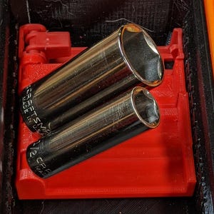 May include: Two silver socket wrenches are held in a red plastic organiser. The wrenches are labelled "Craftsman Made in USA".