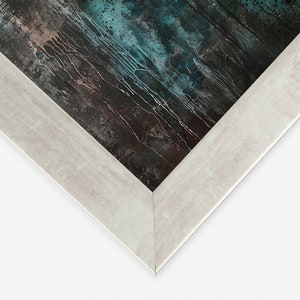 May include: Close-up of the corner of a white wood picture frame. The frame has a slightly distressed finish and surrounds a dark blue and brown abstract painting.