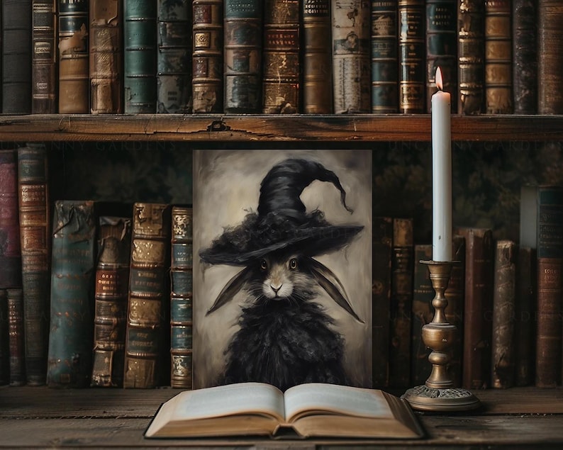 May include: A black rabbit wearing a witch's hat is depicted in a painting. The painting is framed and sitting on a wooden shelf with books and a candle.