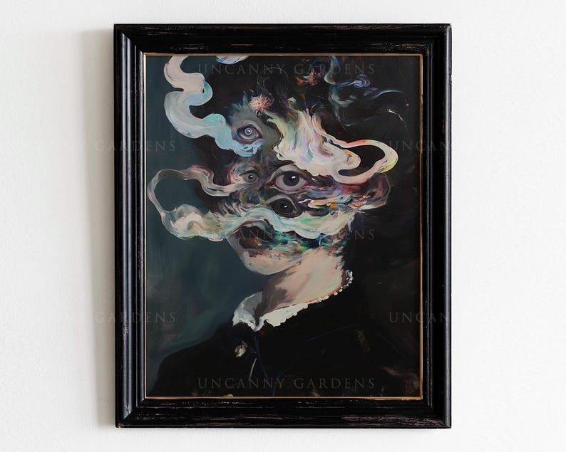 May include: A framed surrealist portrait with a dark background. The artwork features a figure with multiple eyes and swirling, cloud-like forms. The frame is black, and the text "UNCANNY GARDENS" is visible.