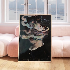 May include: A framed artwork featuring a surreal portrait with multiple eyes and swirling, smoky forms. The subject wears a dark outfit with a white collar. The text "UNCANNY GARDENS" is visible at the bottom of the artwork.