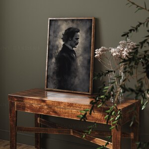 May include: A framed black and white portrait of a man with a mustache, wearing a dark suit and tie. The portrait is set against a textured background with a faded, vintage look. The frame is brown wood.