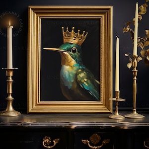 May include: A painting of a green and blue hummingbird wearing a gold crown. The painting is framed in a gold frame and is hanging on a dark wall. There are two candlesticks with lit candles on either side of the painting.