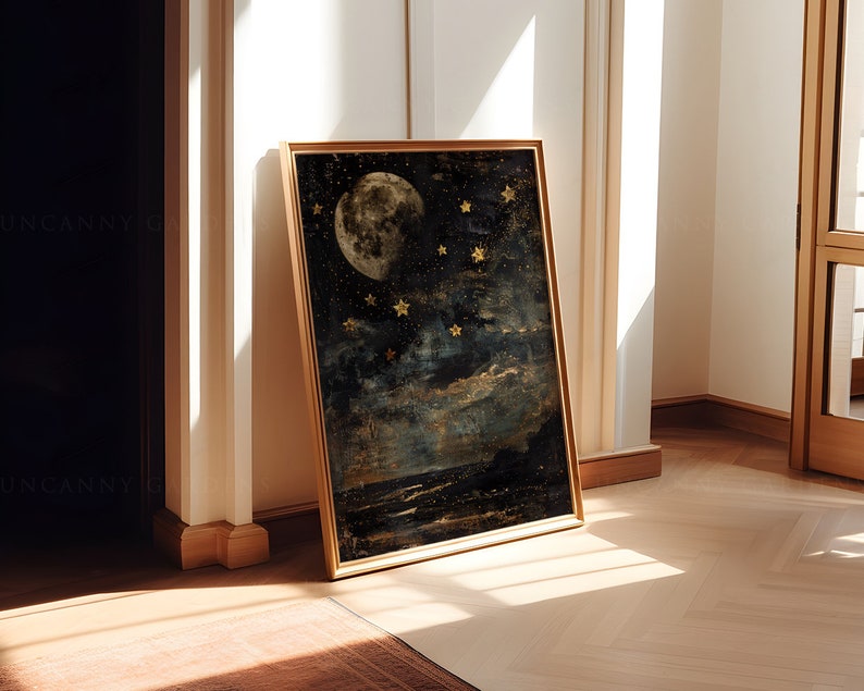 May include: A framed print of a moon and stars in a dark blue and gold color scheme. The moon is full and has a textured surface. The stars are scattered across the sky and are a bright gold color.