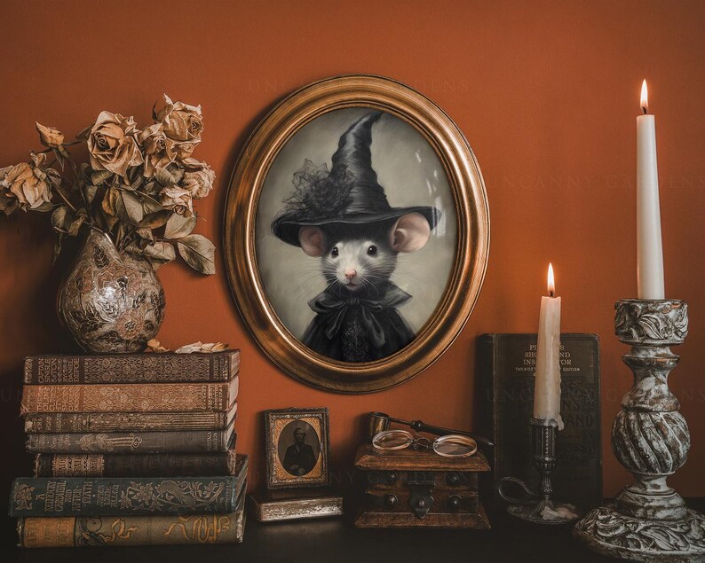 May include: A framed portrait of a mouse wearing a black witch hat and a black dress. The portrait is set against a brown wall with a vase of dried flowers, books, and candles.