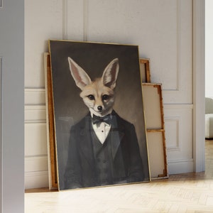 May include: A framed portrait of a fennec fox in a black tuxedo with a bow tie. The artwork has a dark background and a gold frame. The fox has large ears and a sophisticated expression.