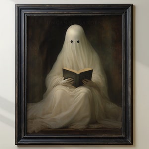 May include: Framed artwork featuring a ghost draped in white fabric, reading a book. The ghost has two black eye holes. The artwork is in a black frame and has the text "UNCANNY GARDENS" at the top.
