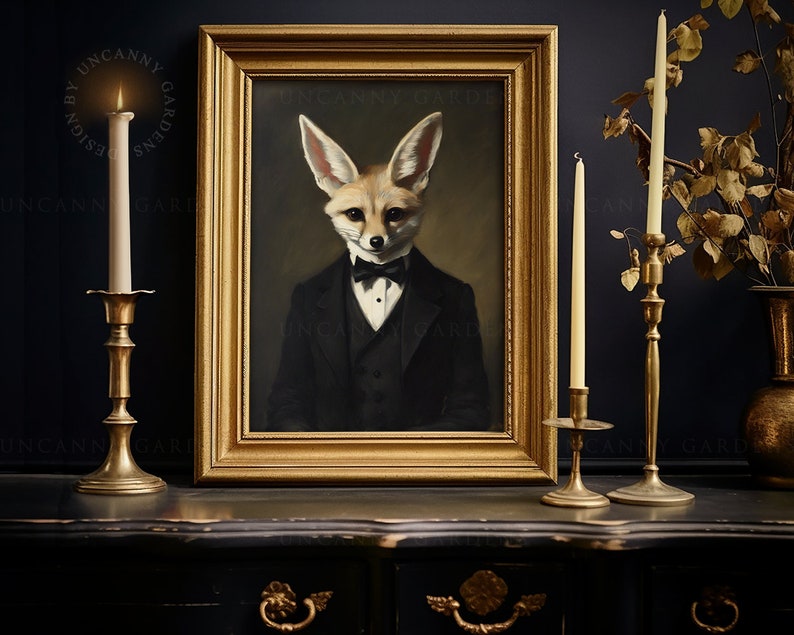 May include: A framed portrait of a fox in a tuxedo and bow tie. The artwork is in a gold frame, and the scene is set on a dark surface with lit candles in gold candle holders. The text "UNCANNY GARDENS" is visible on the frame.