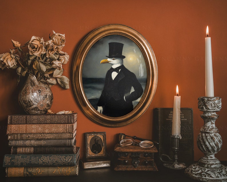 May include: A framed portrait of a seagull wearing a black top hat and a bow tie. The portrait is set against a backdrop of a seascape. The portrait is hanging on a wall with a stack of books, a small framed picture, and two candlesticks with lit candles on either side.
