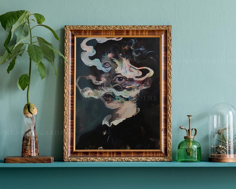 May include: A framed artwork with a surreal portrait. The painting features a figure with multiple eyes and swirling, smoky forms in shades of blue, white, and pink. The frame is ornate with a gold finish. The artwork is displayed on a teal shelf.