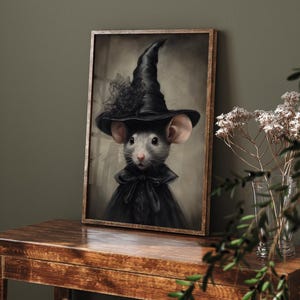 May include: A framed painting of a gray mouse wearing a black witch's hat and a black dress with a lace collar. The background is a muted brown.