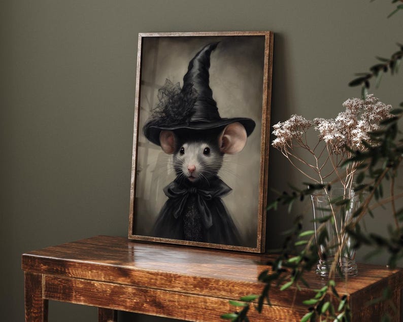 May include: A framed painting of a gray mouse wearing a black witch's hat and a black dress with a lace collar. The background is a muted brown.