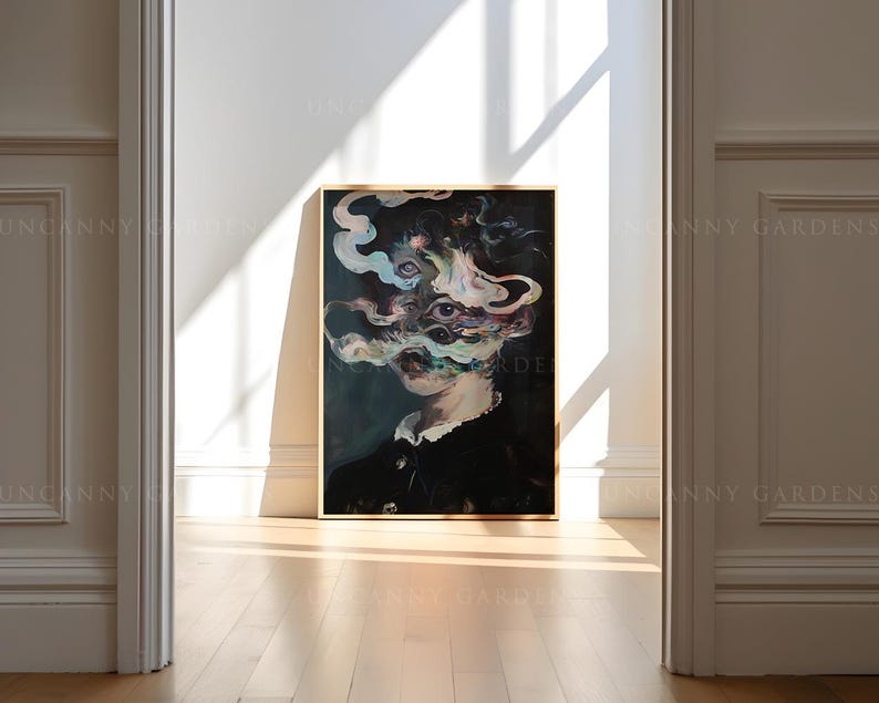 May include: A framed artwork featuring a surreal portrait with a dark color palette. The subject's face is partially obscured by swirling, colorful smoke-like forms. The artwork is displayed in a bright room with sunlight.