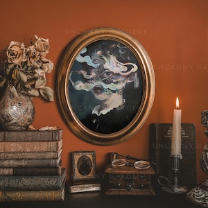 May include: An oval framed portrait with a surreal face, surrounded by candles, books, and a vase of dried flowers. The painting features a woman's face with multiple eyes and colorful smoke-like elements. The scene is set against a warm orange wall.
