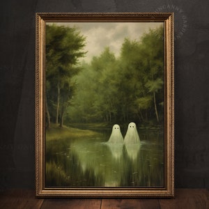 May include: A framed painting of a forest scene with two white ghosts floating in a still lake. The painting is in a gold frame and has a dark green background.