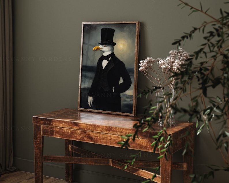 May include: A framed painting of a seagull wearing a top hat and a tuxedo. The seagull is standing in front of a dark background with a faint light behind it. The painting is on a wooden table with a vase of white flowers in the foreground.