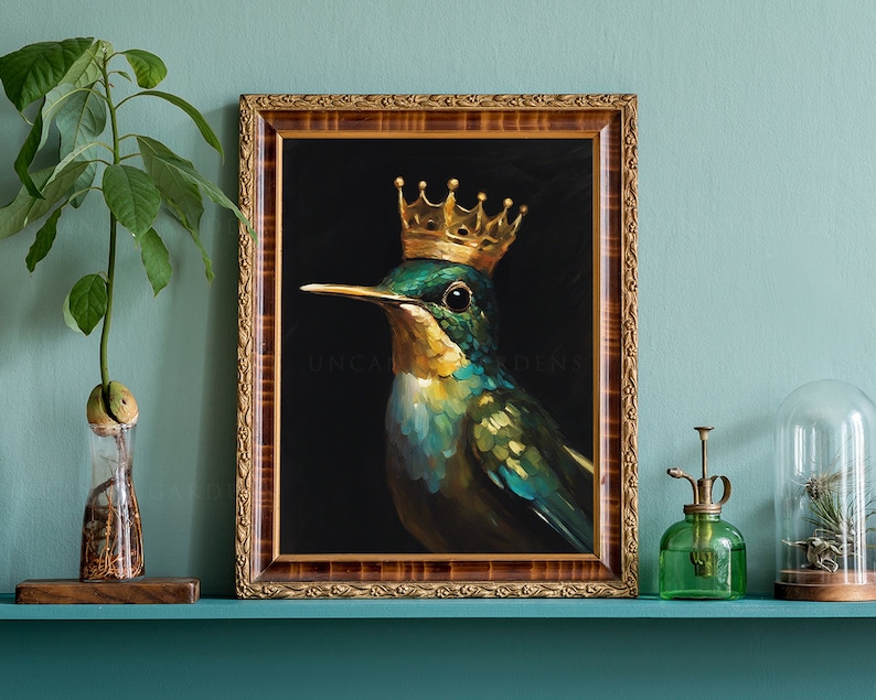 May include: A framed painting of a hummingbird wearing a gold crown against a black background. The painting is titled "Uncommon Gardens".
