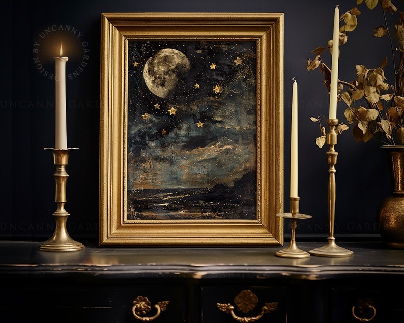 May include: A framed painting of a moon and stars in a dark blue sky with gold accents. The painting is on a black table with two gold candle holders and candles.