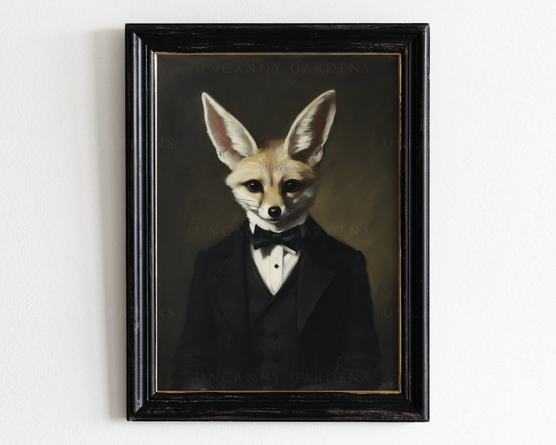 May include: Framed artwork featuring a dapper fox in a black tuxedo and bow tie. The fox has large ears and a refined expression. The artwork is set against a dark background and framed in a distressed black frame. The text "UNCANNY GARDENS" is visible.