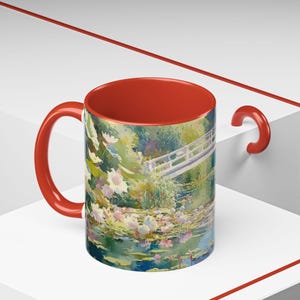 Artistic mug featuring Monet’s water lilies and Japanese bridge, showcasing serene greens, soft pinks, and calm reflections inspired by his iconic garden scenes